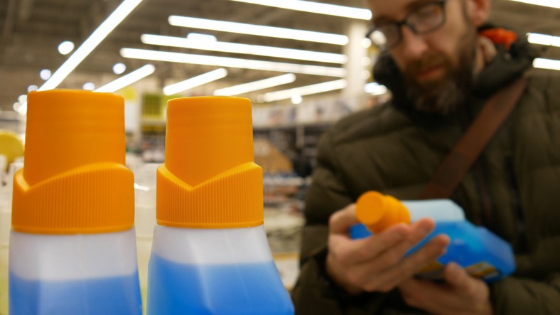 Gros plan sur un client prenant un produit d'entretien en rayon d'un magasin de quincaillerie
